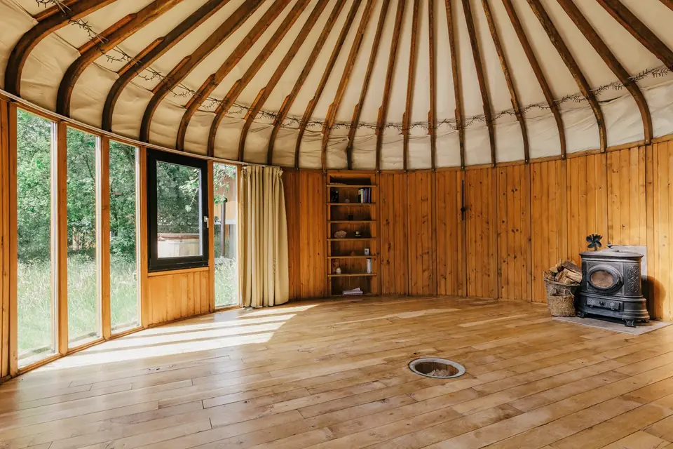 Holzjurte im AVANI Retreat Center in Helvoirt: runder Raum mit Holzboden und Ofen